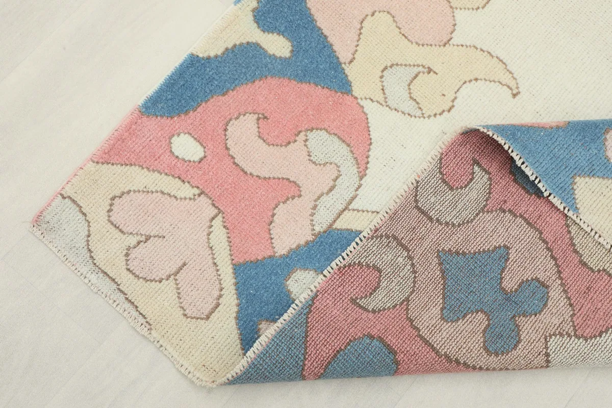 Rug folded to reveal the backside, showing the cotton foundation and knotting structure.