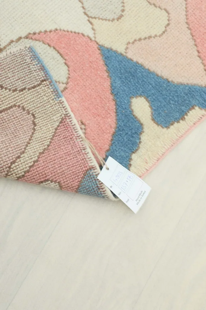 Rug tag visible on the back of the rug, indicating its origin and material.