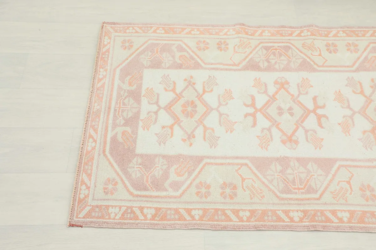 Detail showing the intricate rose border design and the stylized floral patterns within the ivory field.