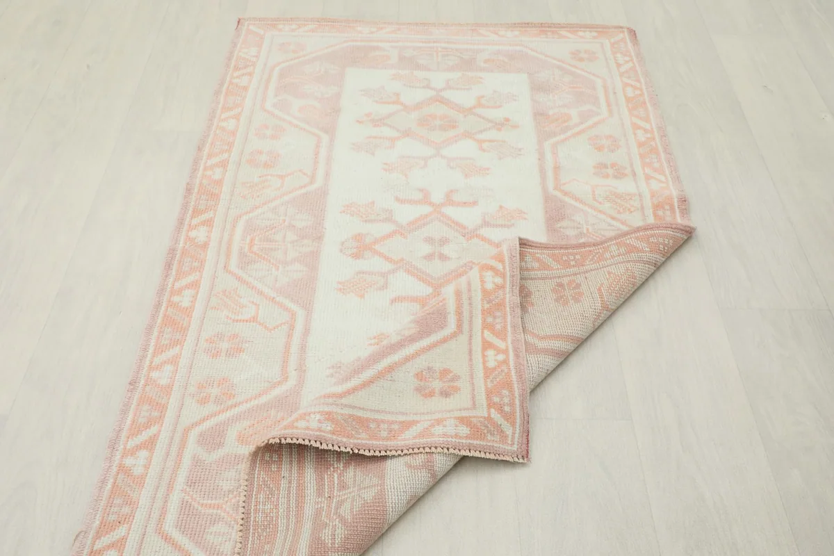 Rug partially folded, illustrating the flexibility and thickness of the hand-knotted wool pile.