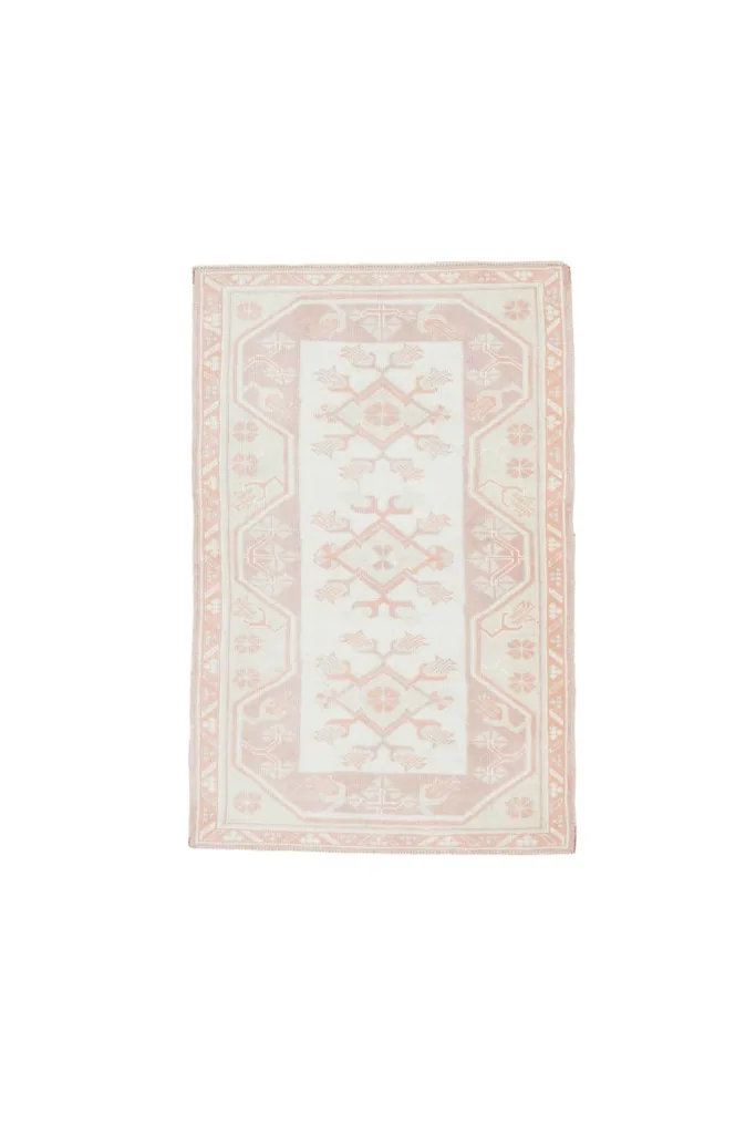 Full overhead view of the 2'9" x 4'4" rose and ivory vintage Anatolian rug on a white background.