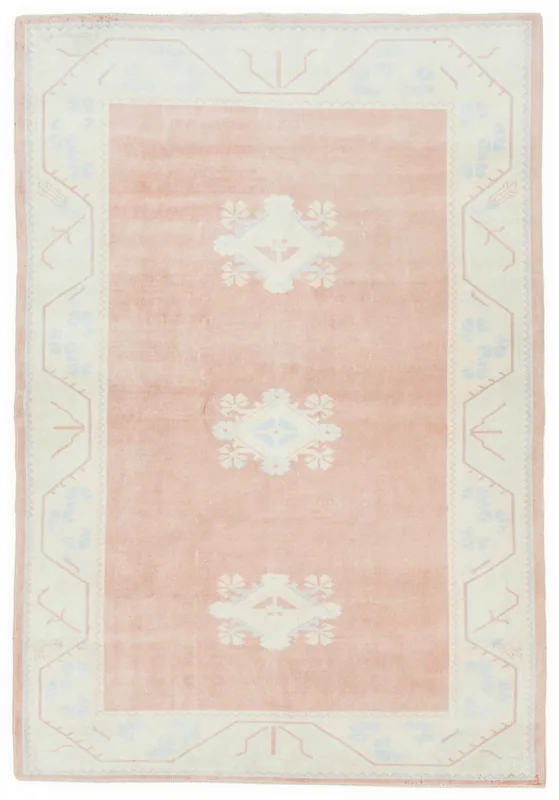 Full overhead view of the 5'3" x 7'8" vintage Anatolian area rug with rose field and ivory geometric patterns