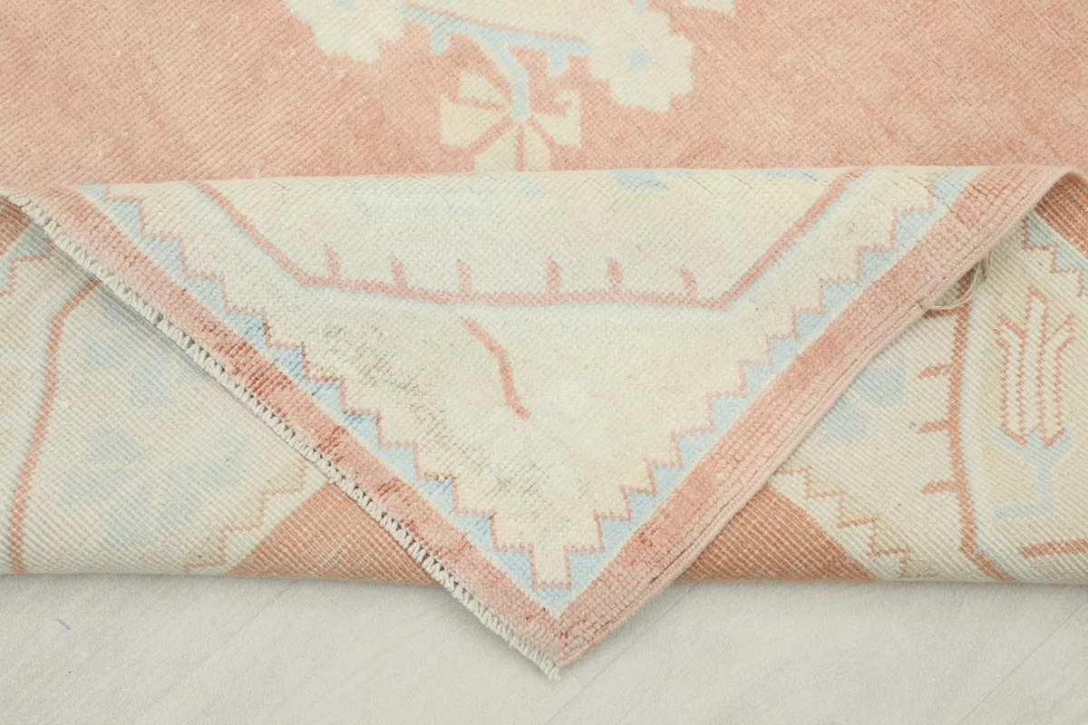 Folded corner of the rug revealing the hand-knotted cotton foundation and reverse side of the pattern