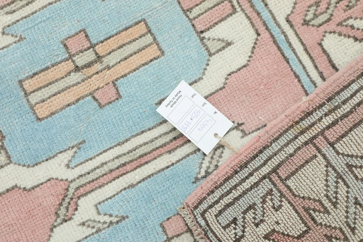 Rug with a product tag placed on its surface, indicating details and quality.
