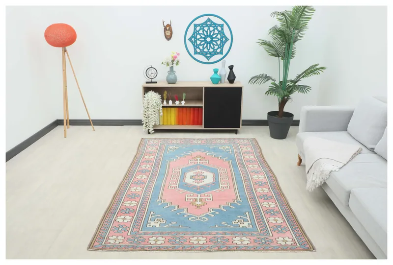 Full top view of the 5x7 blue and pink vintage Anatolian area rug on a white background.