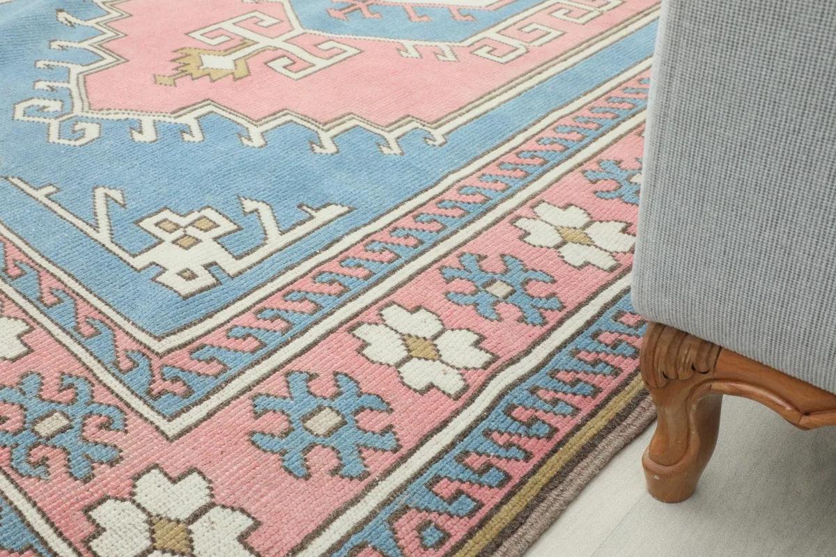 Rug corner next to a chair leg, illustrating its placement in a home decor setting.