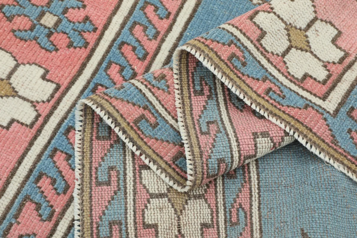 Folded section of the rug, highlighting the texture and color variations in the pile.