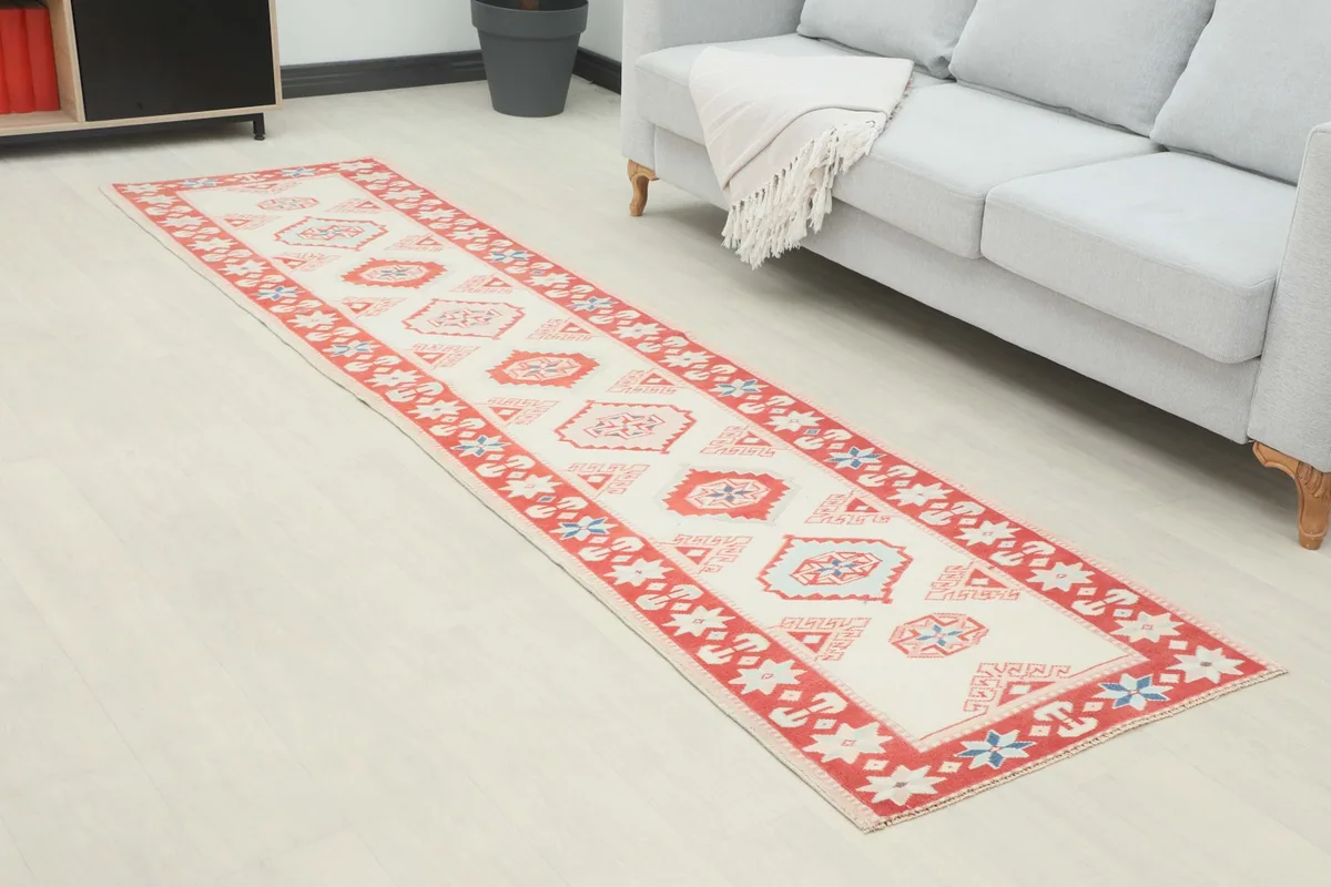 Angled view of the runner rug extending along a hallway next to a sofa
