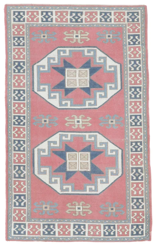 Full top view of the 4'0" x 6'9" rose and navy geometric Anatolian rug on a white background