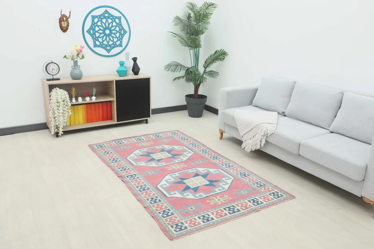 Vintage Anatolian rug with rose field and navy geometric patterns in a modern living room setting