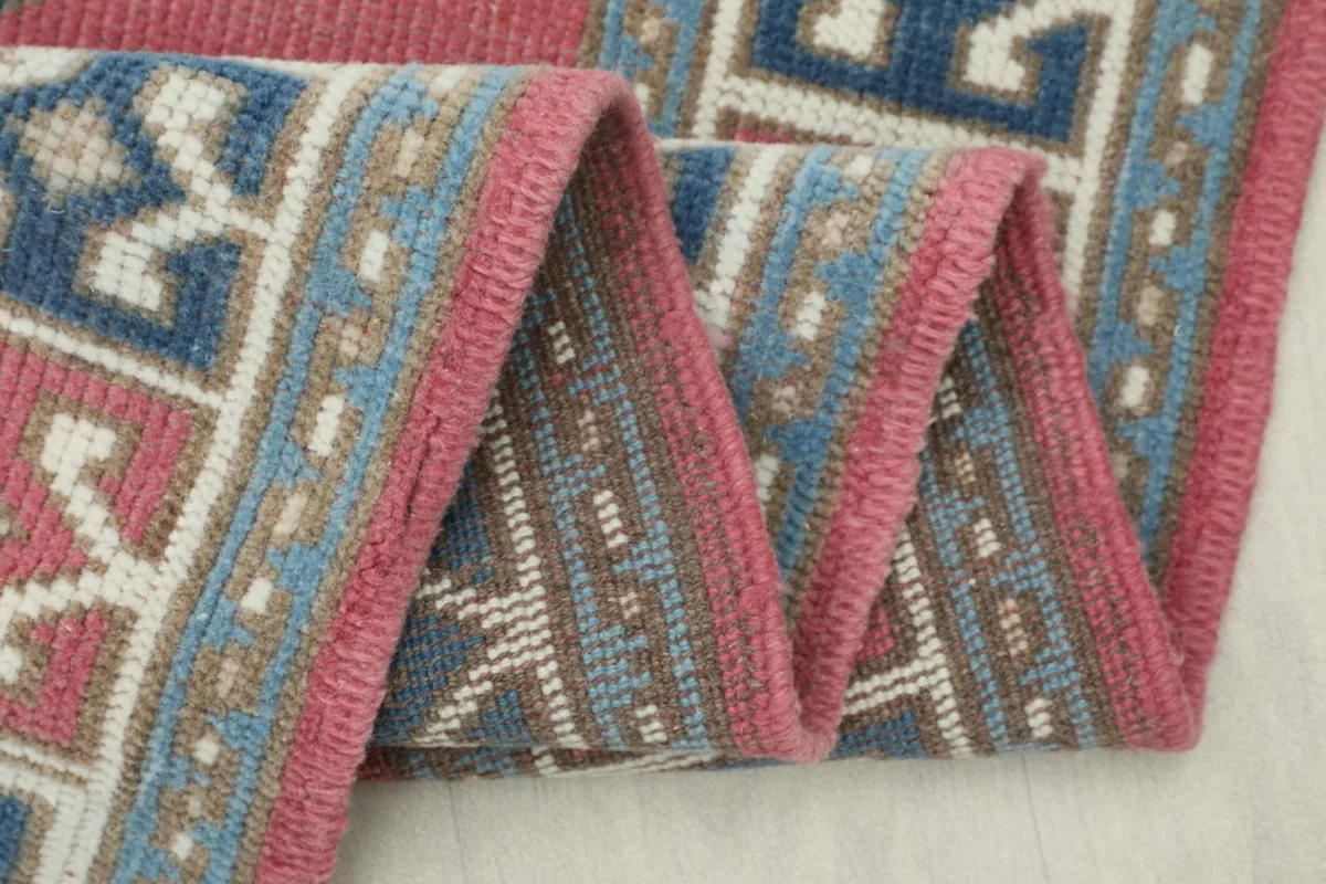 Close-up of the rug's low pile, showing the texture and detail of the hand-knotted wool