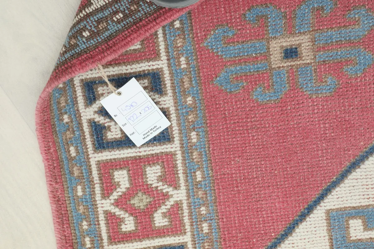 Detail of the rug's back, showcasing the hand-knotted construction and a product tag