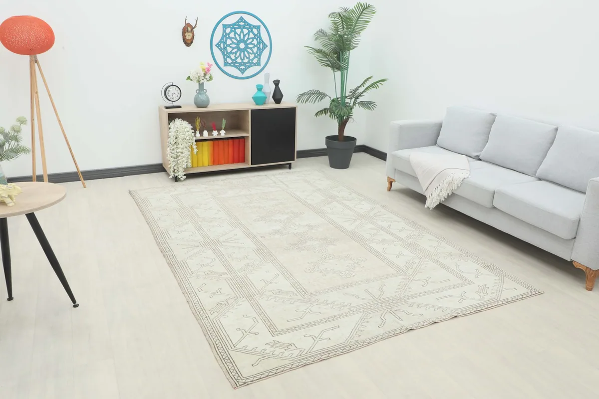 Vintage cream rug displayed in a modern living room setting with a gray sofa