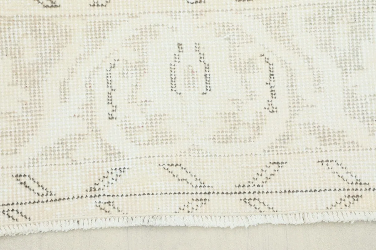 Close-up of the rug's subtle geometric pattern on the fringe end