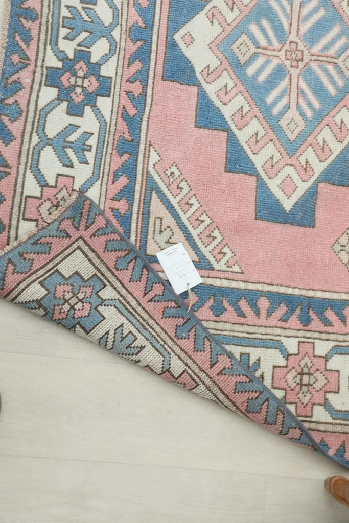 Underside of the rug with a label, showing the cotton foundation and knotting
