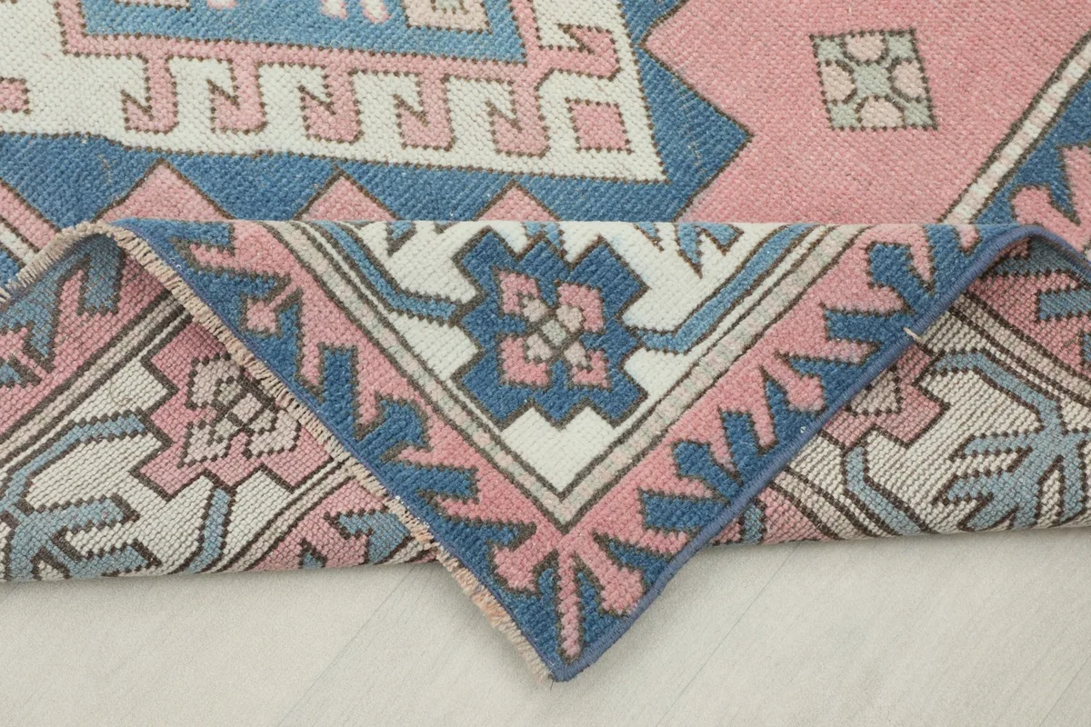 Folded corner of the rug, showing the back and the hand-knotted construction