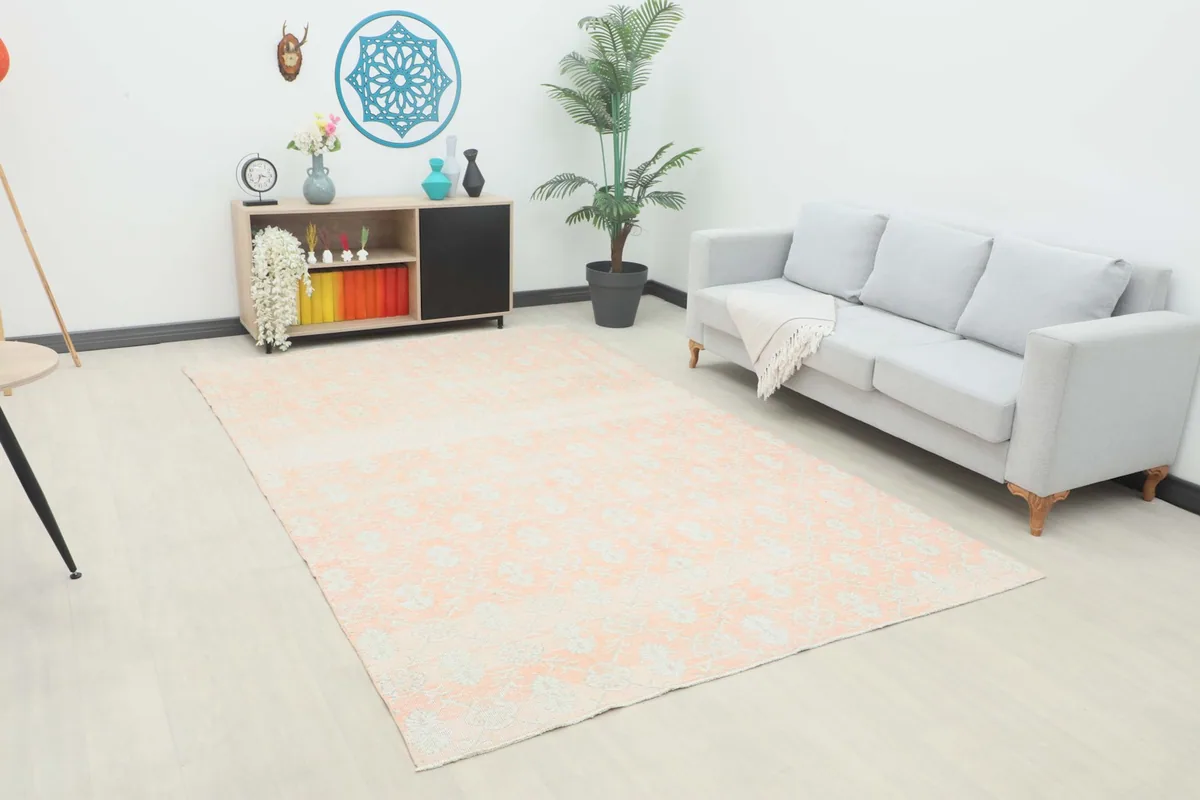 Vintage rose Anatolian rug displayed in a living room setting with a light gray sofa