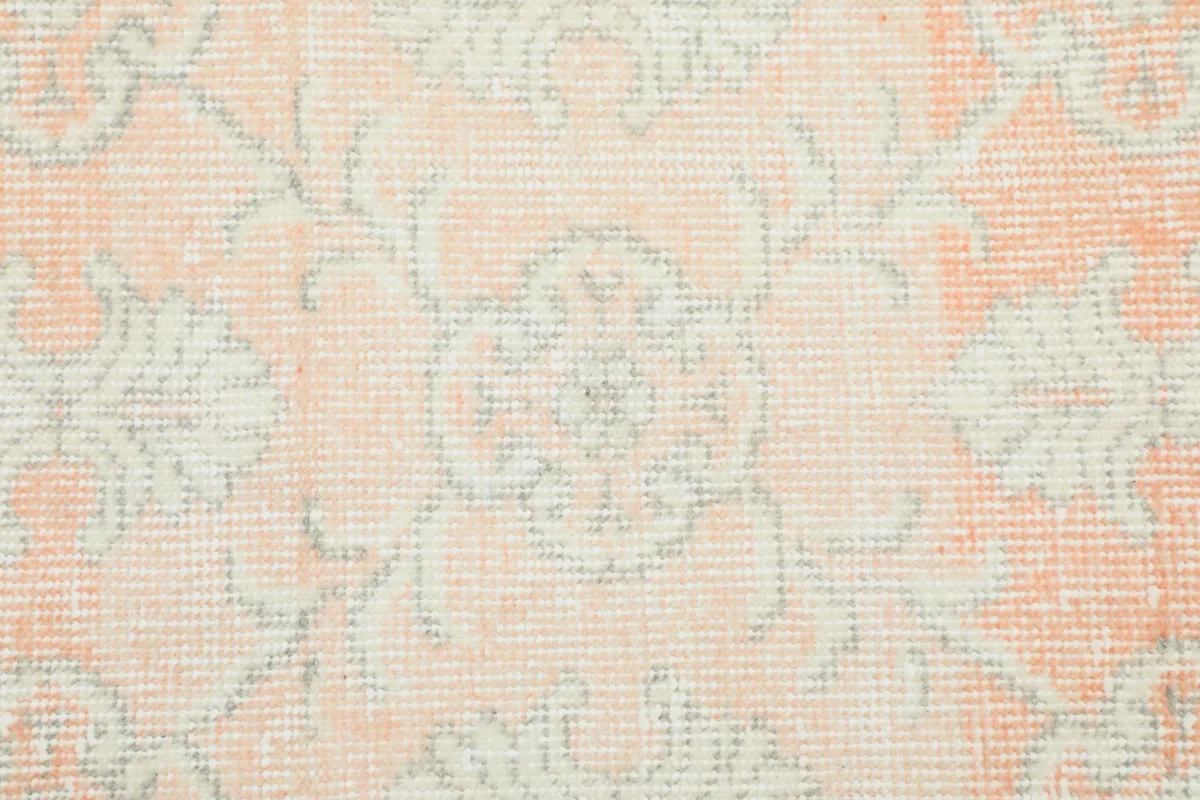 Close-up of a central geometric motif, highlighting the low pile and vintage wear