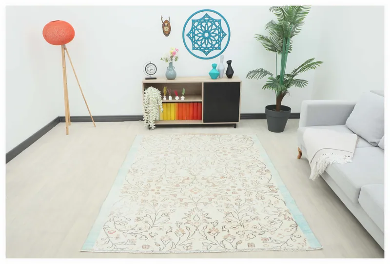 Full overhead view of the 5'6" x 7'1" cream and tan floral vintage rug on a white background.