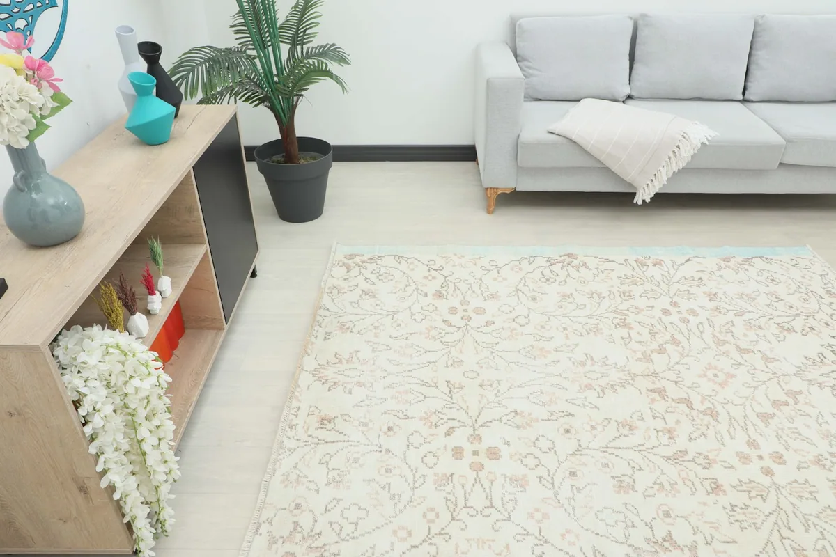 Angled view of the rug in a living room, showing its placement relative to a sofa and decorative elements.