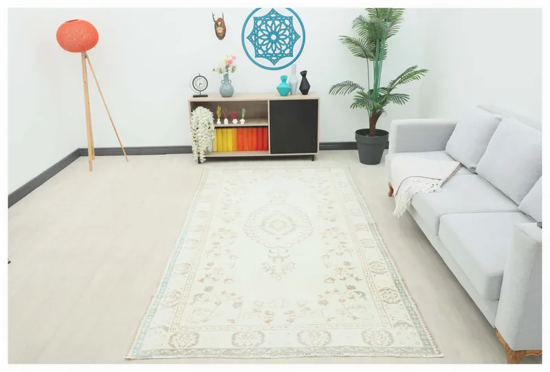 Full top view of the 4'11" x 8'10" ivory Anatolian rug with a central medallion on a white background.