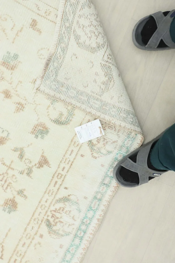 View of the rug's back and fringes, with a tag visible, showing the hand-knotted construction.