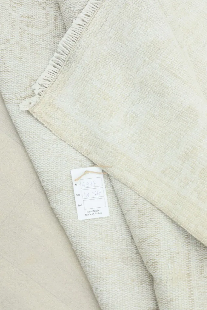 Back of the rug showing the label with product information and the hand-knotted cotton foundation.