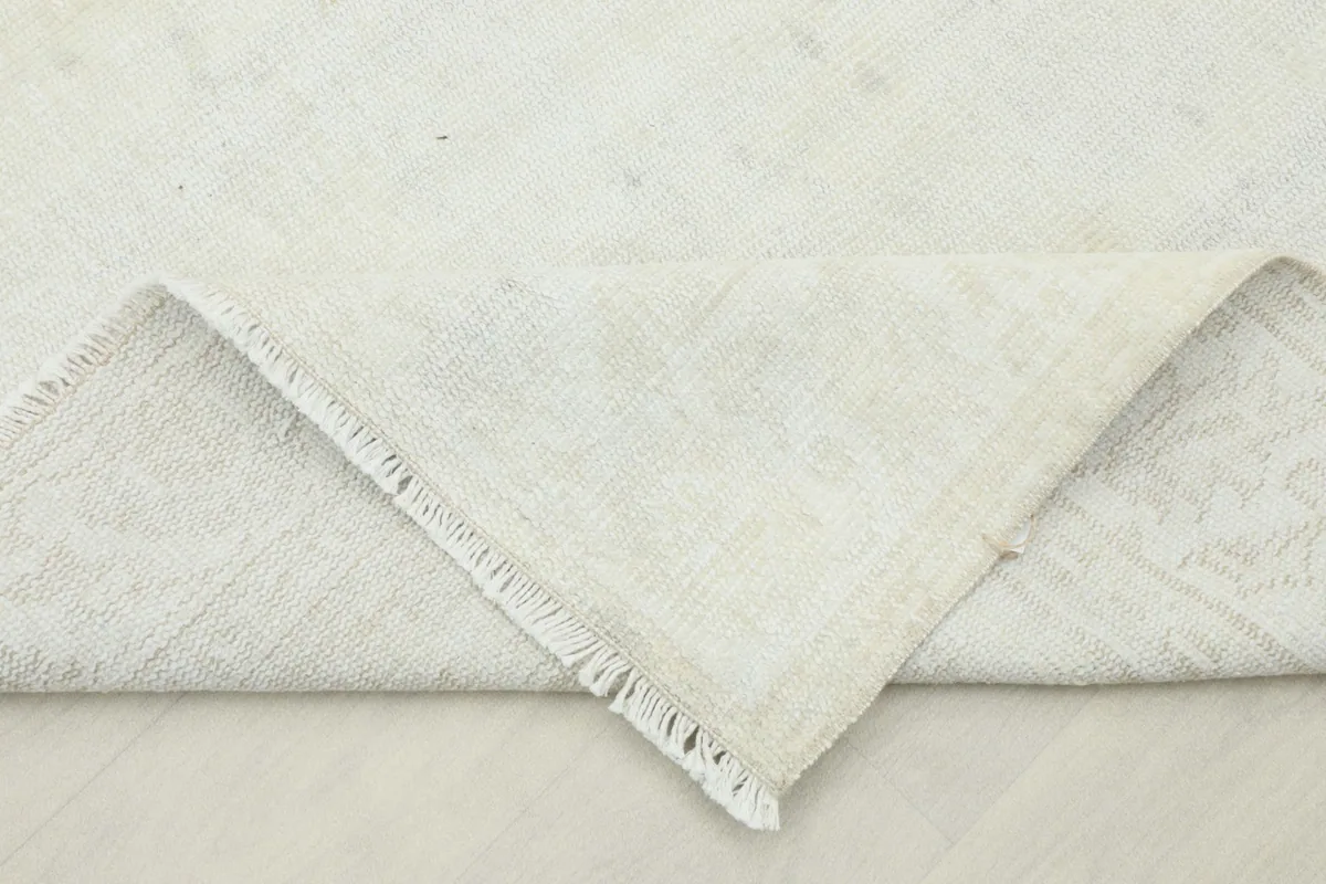 Folded corner of the rug, displaying the pile and the clean cotton foundation.