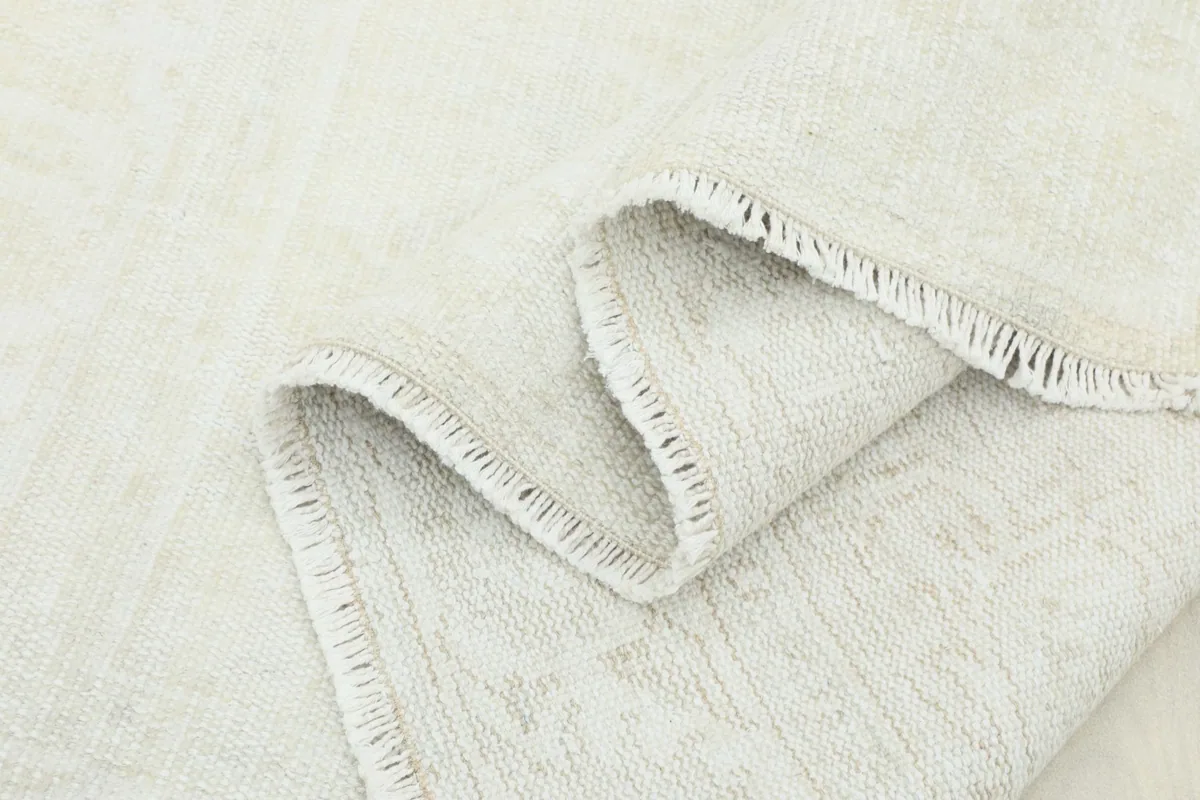 Close-up of the rug in a soft fold, highlighting the low pile and texture.