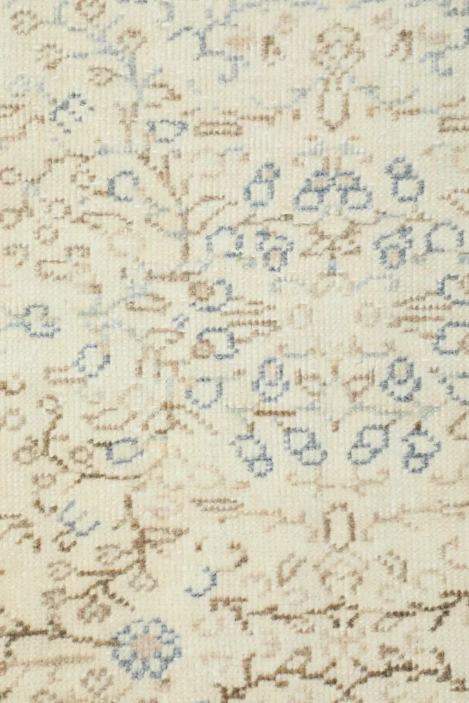 Detailed view of the hand-knotted wool pile and intricate floral motifs on the vintage rug