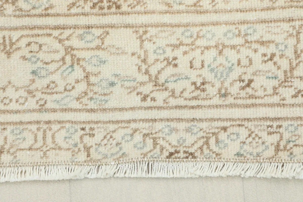 Detailed view of the rug's short, natural fringe and a section of the patterned border