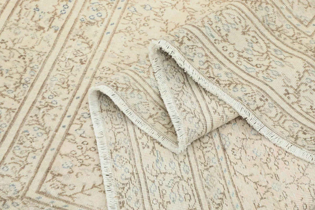 Close-up of the rug's border and fringe, with a section folded to show the weave