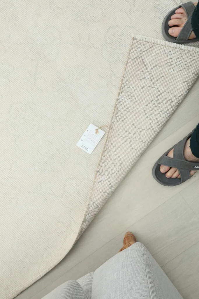 Overhead view of the rug's reverse side, showing the hand-knotted construction and a product tag.