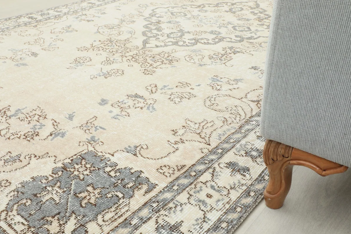 A close-up of the rug next to a sofa leg, showing its texture and how it complements the room decor.