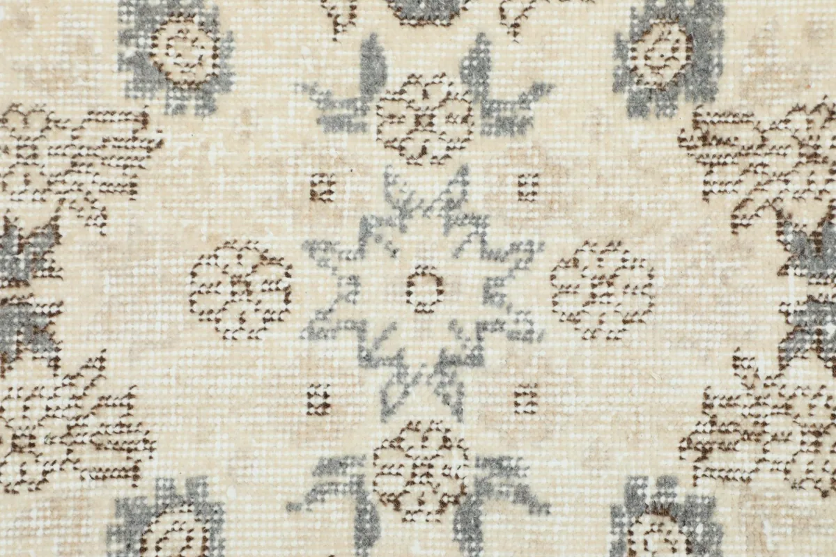 Extreme close-up showcasing the hand-knotted wool pile and subtle color variations within the rug's pattern.