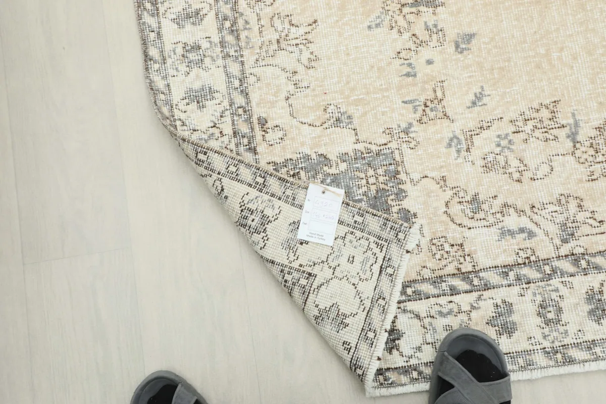 View of the rug's underside and a corner tag, showing the cotton foundation and authentic construction.
