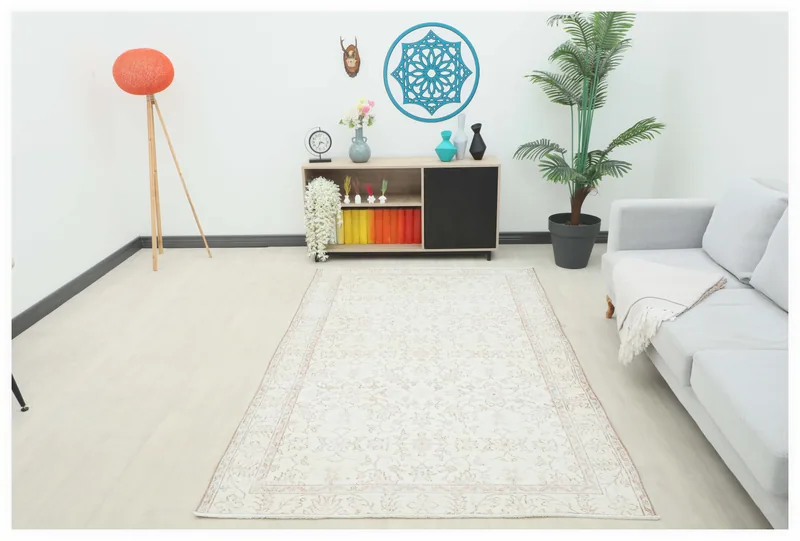 Full overhead view of the ivory and rose floral vintage Anatolian rug on a white background.