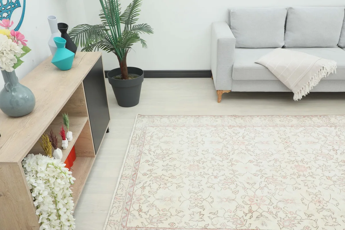 View of the rug in a room, showing its placement next to a light wood cabinet and sofa.