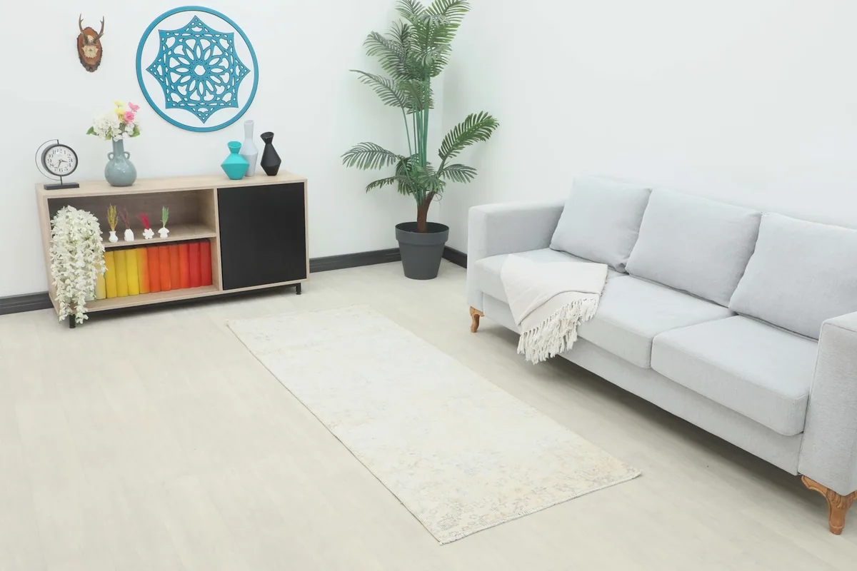 Vintage cream runner rug displayed in a modern living space with a gray sofa and wooden console.
