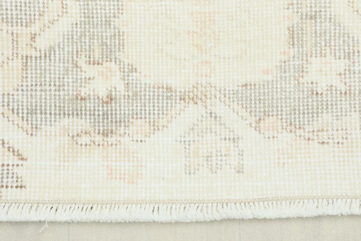 Close-up showing the subtle gray and beige tones in the rug's border pattern