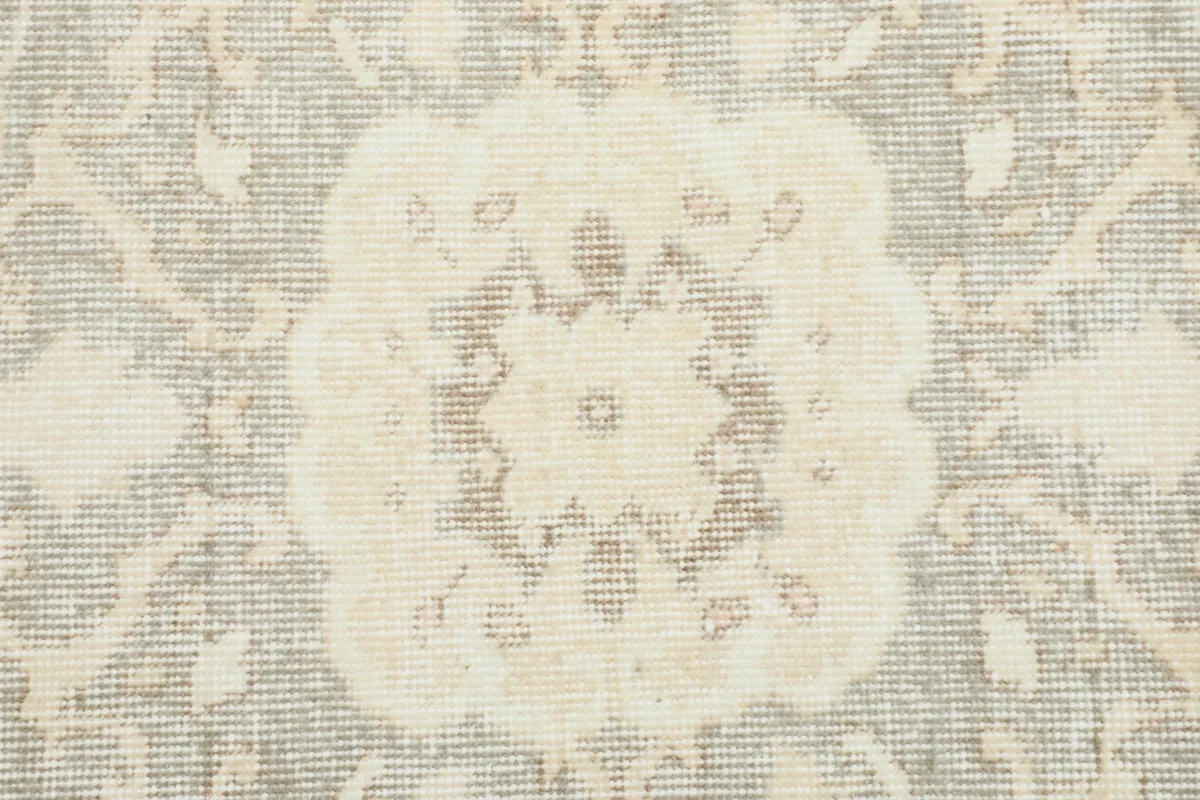 Detailed view of the hand-knotted pile and subtle color variations in the gray motifs