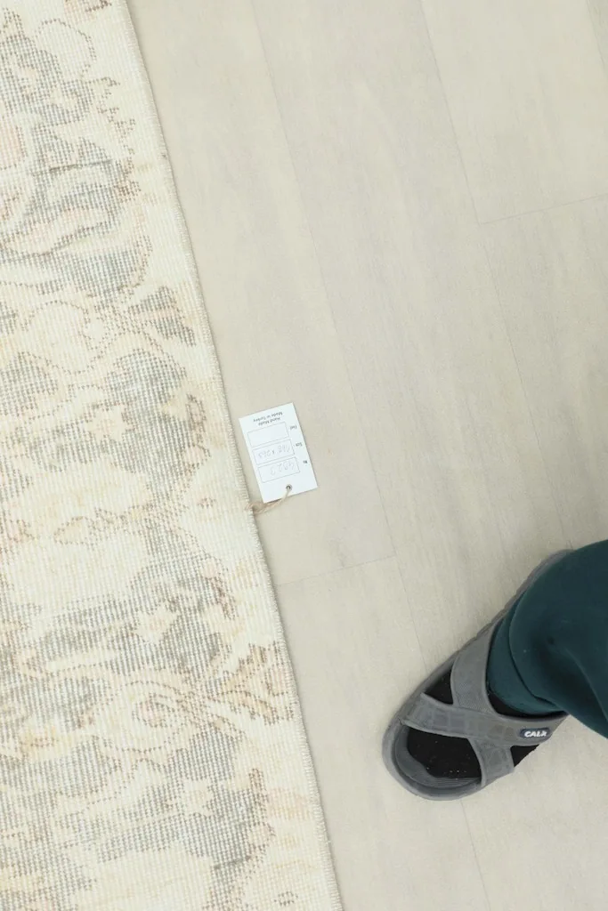 Overhead shot showing the rug's label and a foot for scale reference