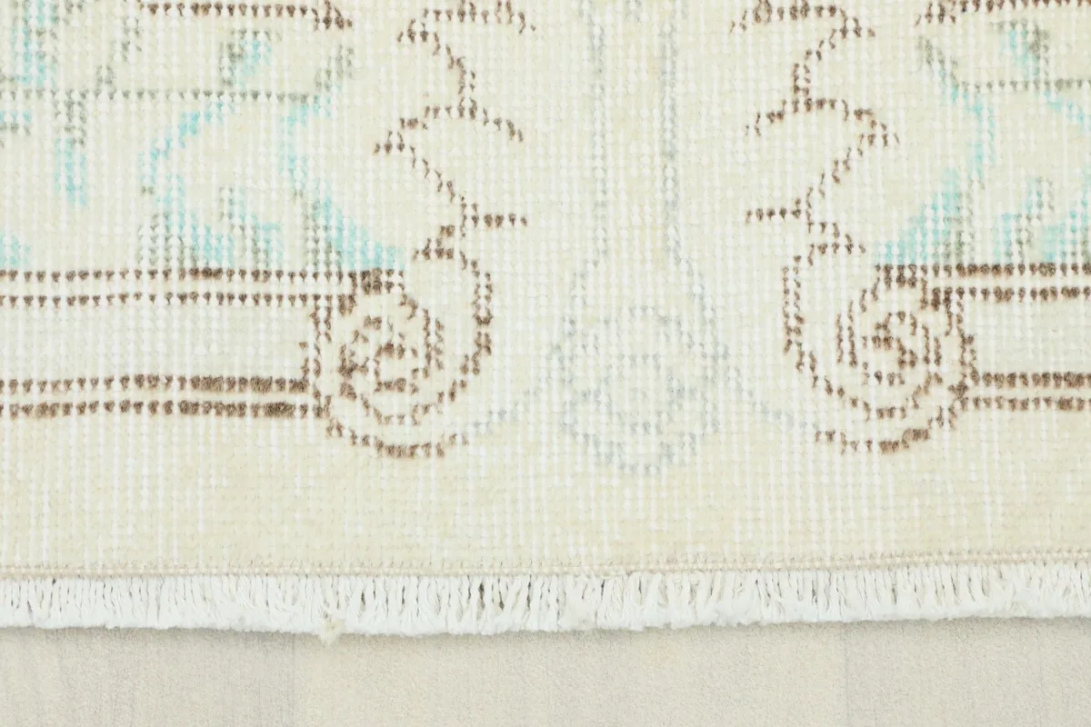 Detailed view of the rug's pile and subtle color variations near the edge