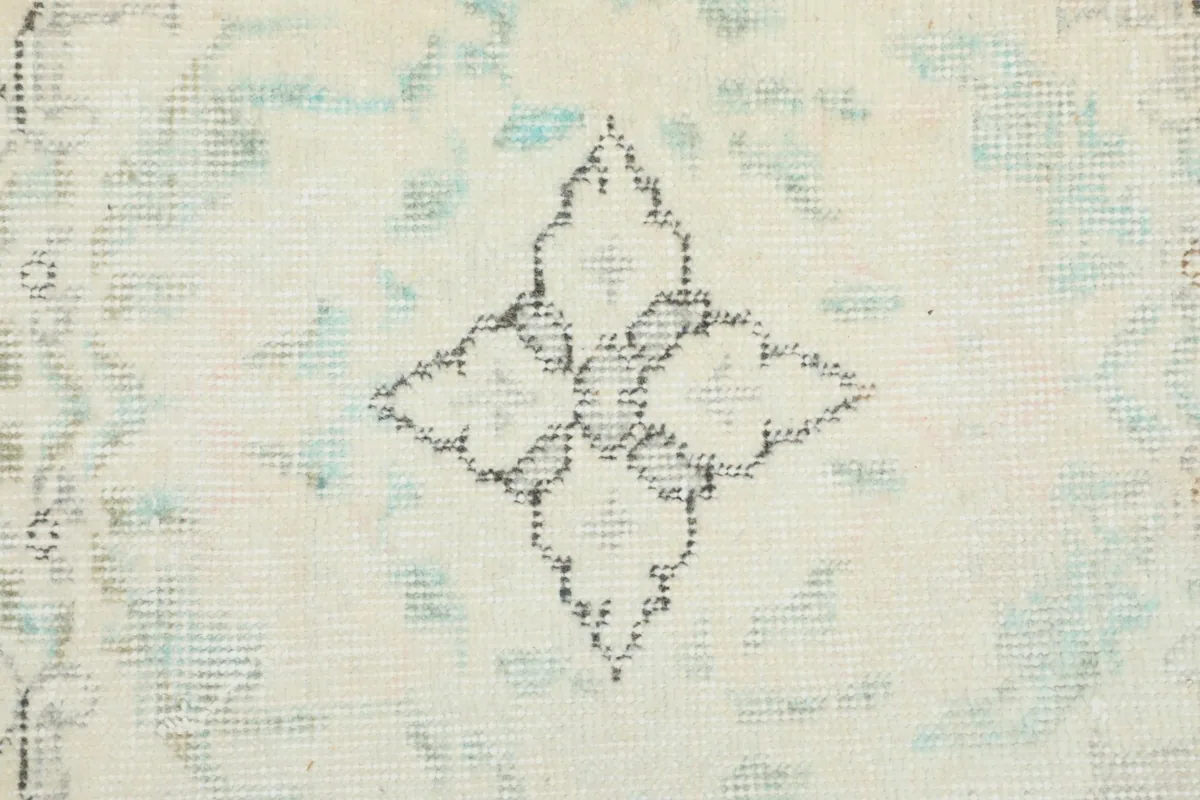Detailed shot of a faded blue floral element within the rug's design