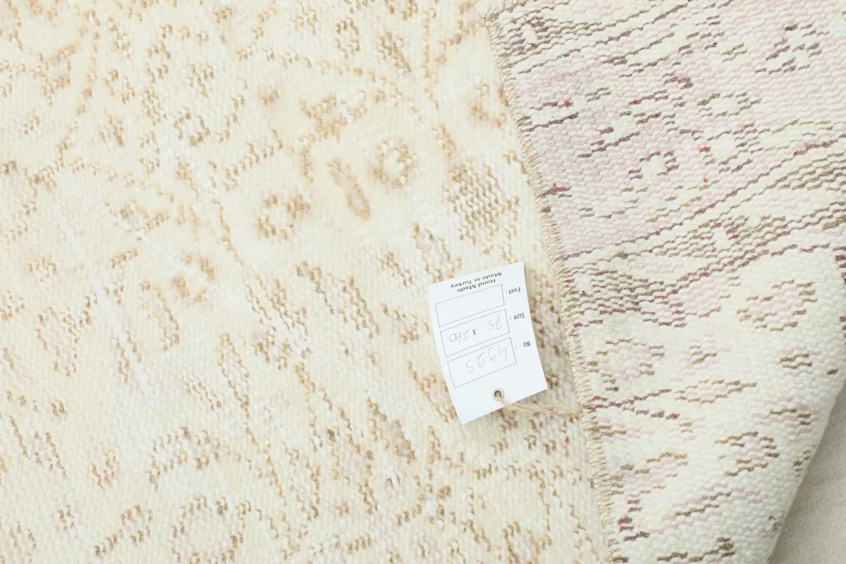 Underside of the rug with a tag, showing the reverse weave and craftsmanship.