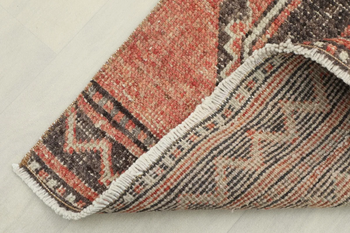 Corner of the runner folded to reveal the cotton foundation and the reverse side of the hand-knotting.