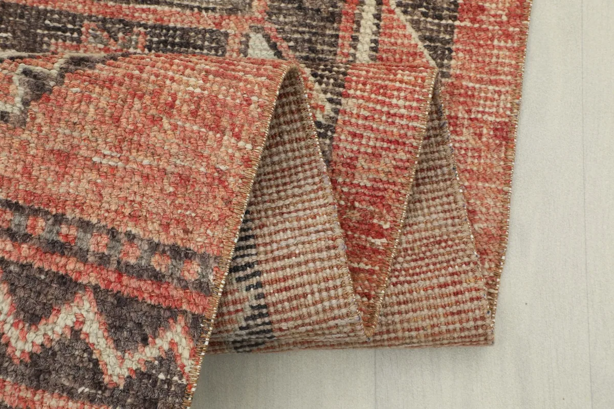 Close-up of the folded rug, highlighting the texture and color blending of the wool pile.
