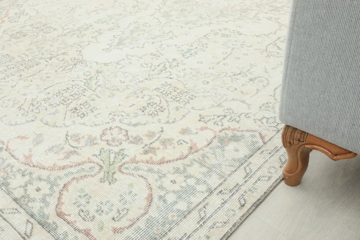 Detailed view of the rug's border and a sofa leg, showing pile height