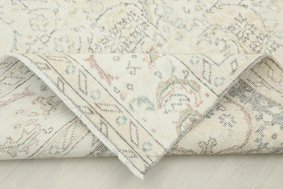 Corner of the rug folded back to show the cotton foundation and hand-knotted construction