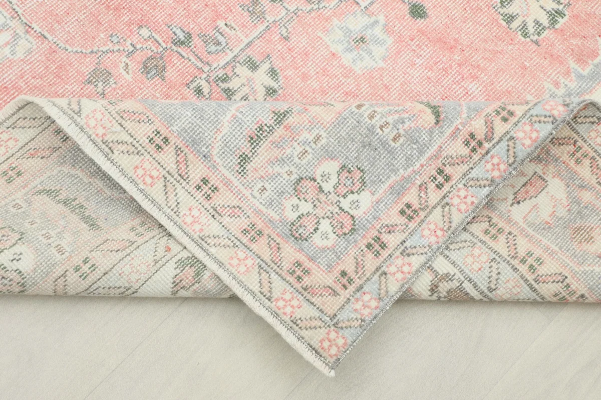 Corner of the hand-knotted wool rug folded to show the back and detailed weaving.